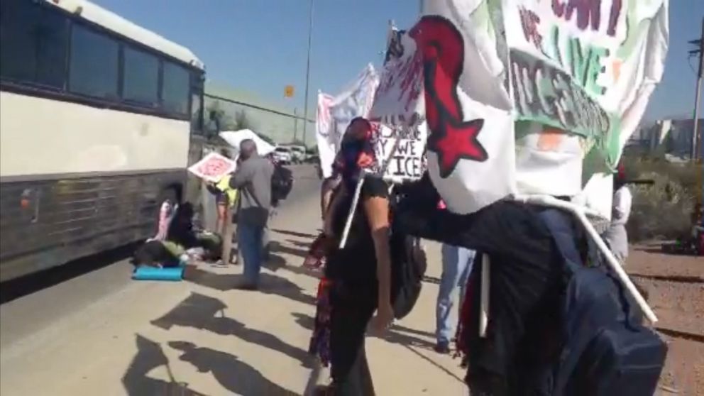 PHOTO: A group of immigrant rights activists block a bus filled with detainees headed to federal court in Tucson, Ariz., Oct. 11, 2013.