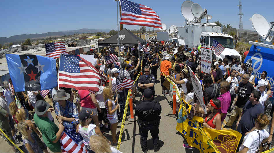 Police officers separate demonstrators on opposing sides of the immigration debate outside a U.S. Border Patrol station in Murrieta, Calif., on July 4.