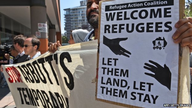 A protestor holds up a pro-refugee placard at a rally