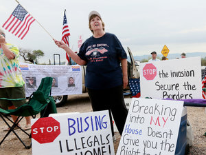 Anti-immigration activist Judy Lairmore protests busing of migrant people from Central America on July 15, in Oracle, Ariz. Many immigrants have been moving into the suburbs in recent decades. And that's creating new tensions with the people who live there.