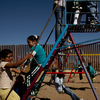 Children play near a border fence at the Escuela Primaria Federal Profesor Ramon Espinoza Villanueva, a primary school in Palomas, Mexico. Palomas borders Columbus, N.M., its sister village.